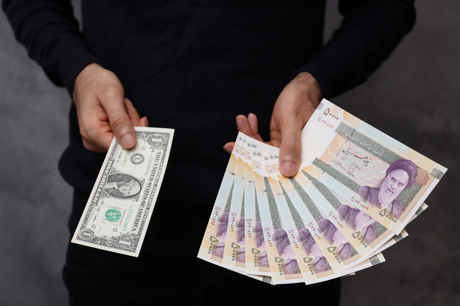یک دلال ارز، دلار آمریکا و ریال ایران را در یک صرافی در تهران نگهداری می کند