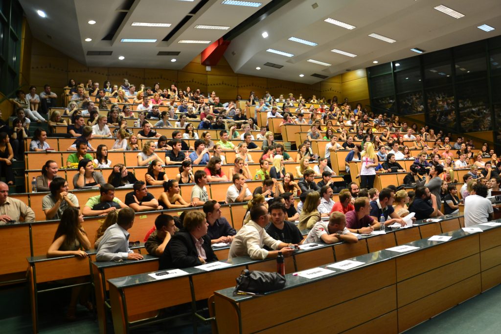 A group of people sitting in a lecture hall Description automatically generated