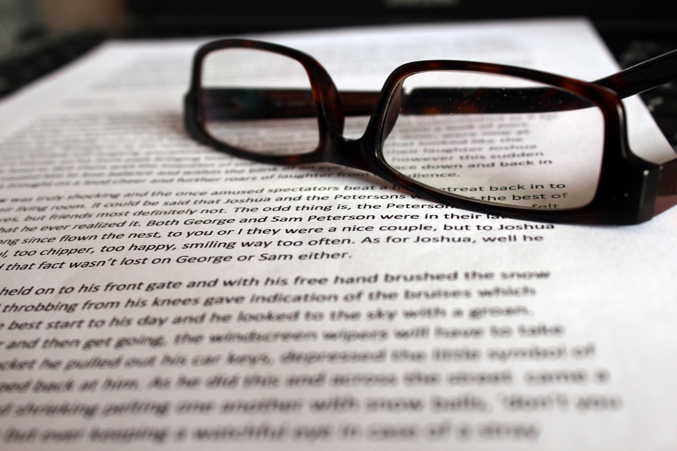 A close-up of a pair of glasses on a piece of paper Description automatically generated